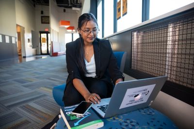 NAU student typing on a laptop in the lobby of the International Pavilion.