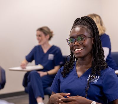 An NAU College of Nursing student smiles while talking to classmates on the Flagstaff Campus.