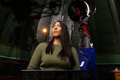 Ana Morgan stands in front of a telescope.