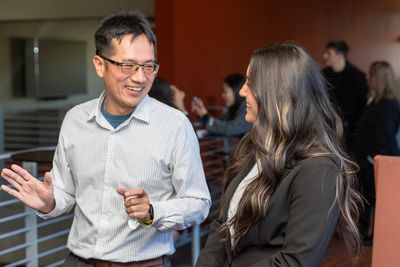 A professor and student talk in the W. A. Franke College of Business.
