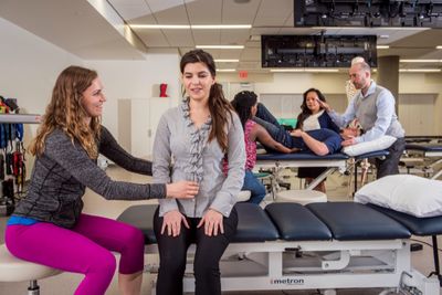 Patient sits on a medical bed at the Phoenix Bioscience Core for physical therapy.