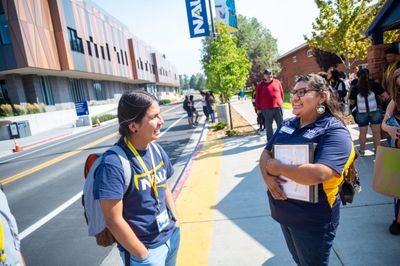 A prospective student asks their tour guide questions while exploring the NAU Flagstaff campus.