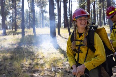 An NAU forestry student smiles while assisting with a prescribed fire for the first time.