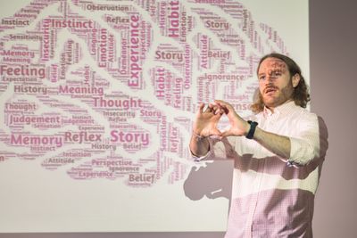 A professor of psychology presents on the brain in a class.