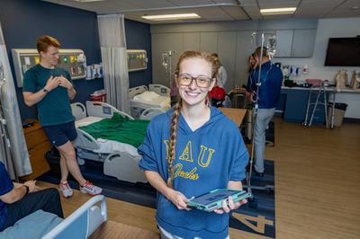 Sara Thomasson, Doctor of Physical Therapy Program, holds a clipboard and smiles for the camera.