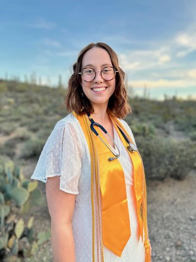 NAU graduate, RN Rachel Stearns, poses and smiles for a picture.