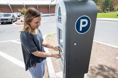 A student uses a parking kiosk on campus to purchase a parking ticket for their vehicle.