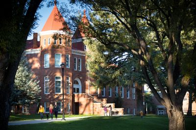 Students walking past the Old Main building in the north quad at NAU.