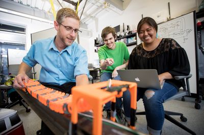 NAU informatics students work together on a mechanical engineering project.